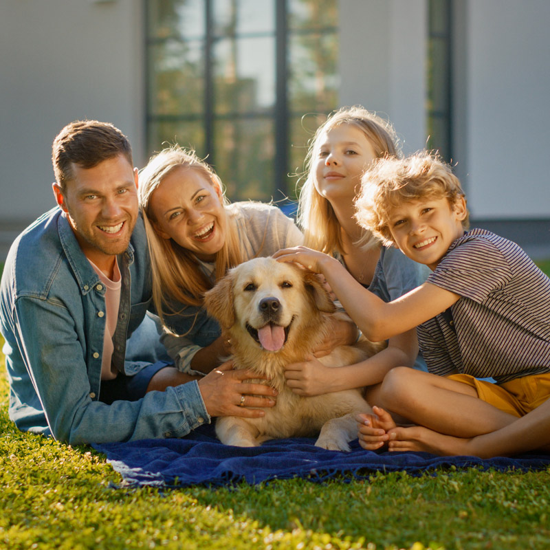 young family in yard with family dog